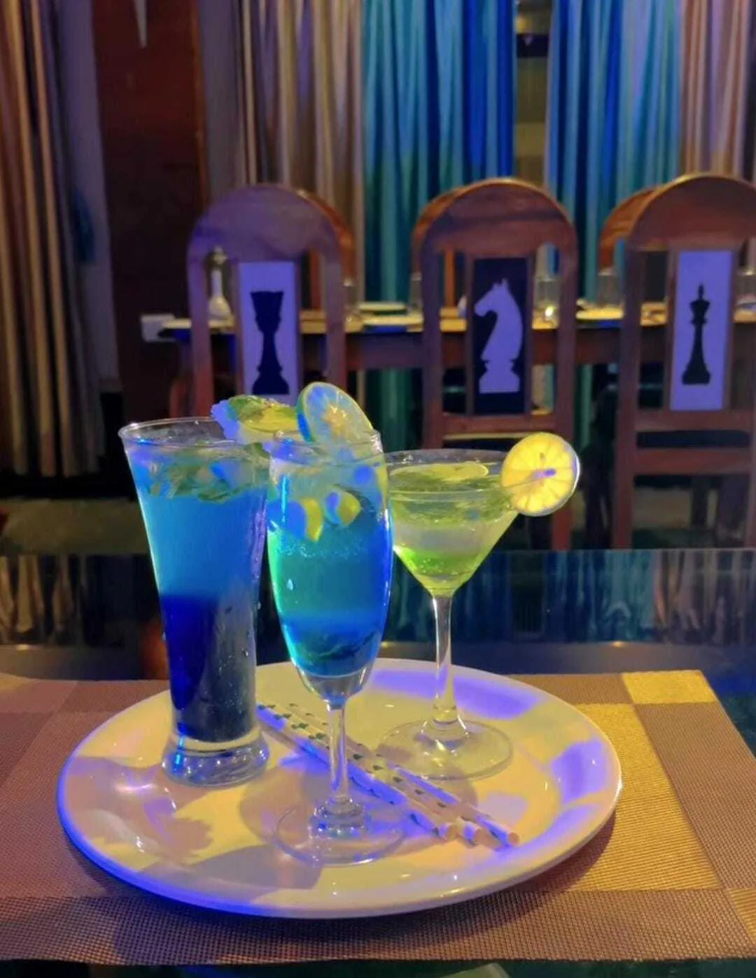 Cold drinks on a tray at Byanjan, with chess-piece chairs behind