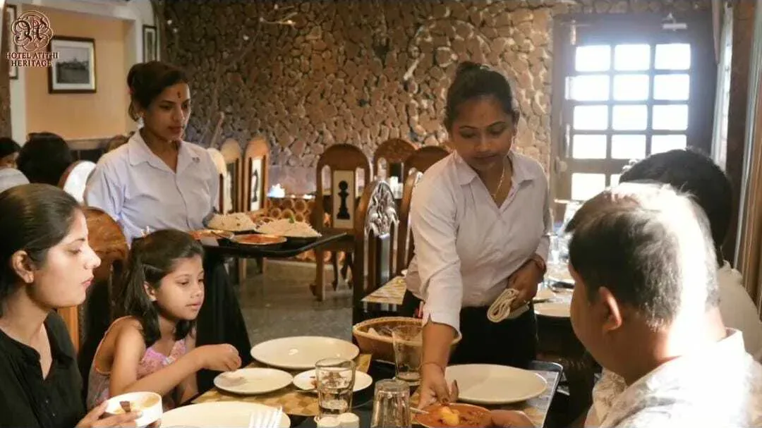Servers attending a family at a table at Byanjan