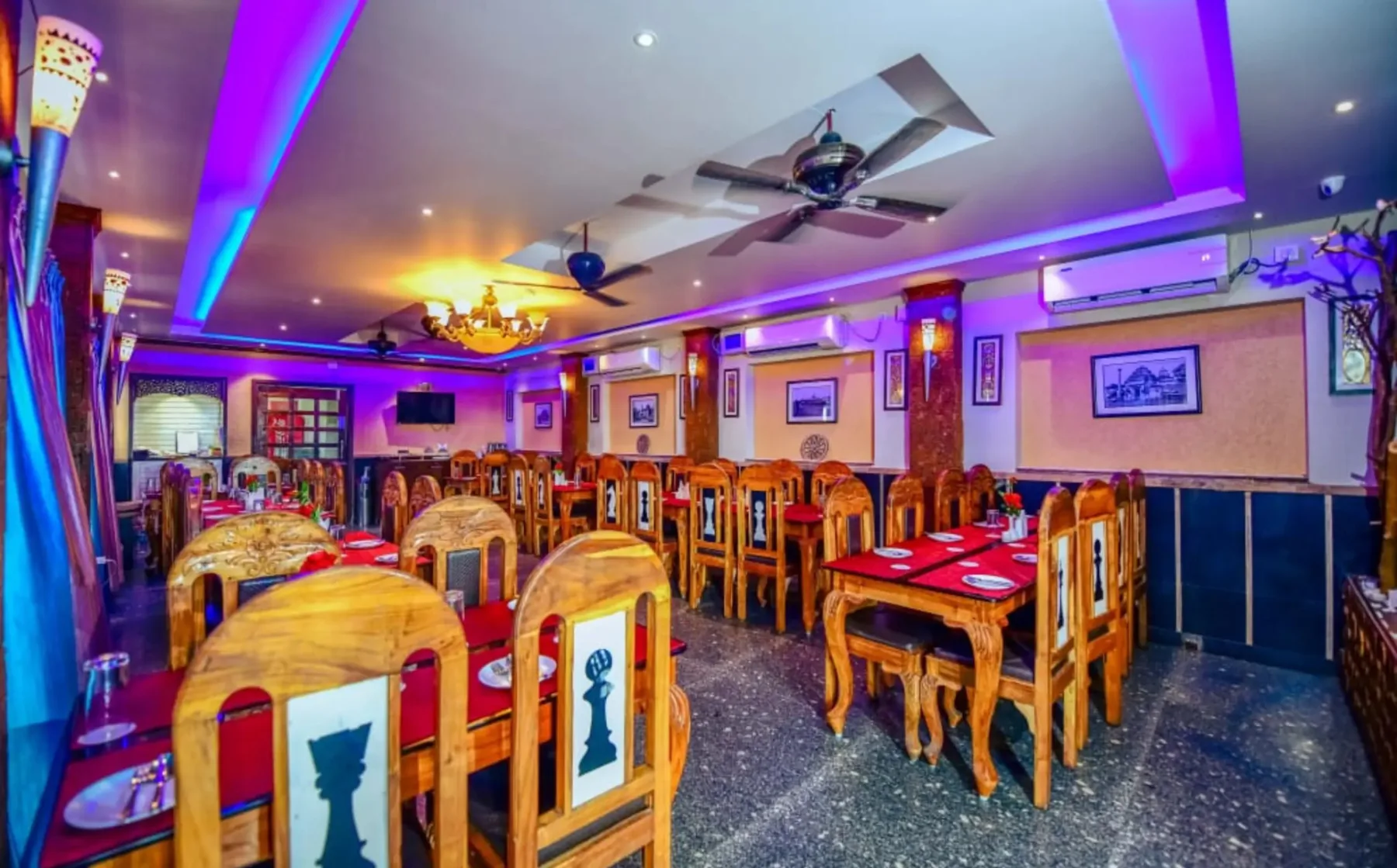 Byanjan dining room in Puri, wooden tables laid for service under ceiling fans