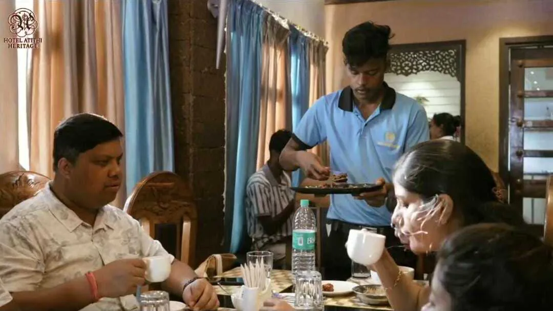 A server bringing a plate to guests at Byanjan